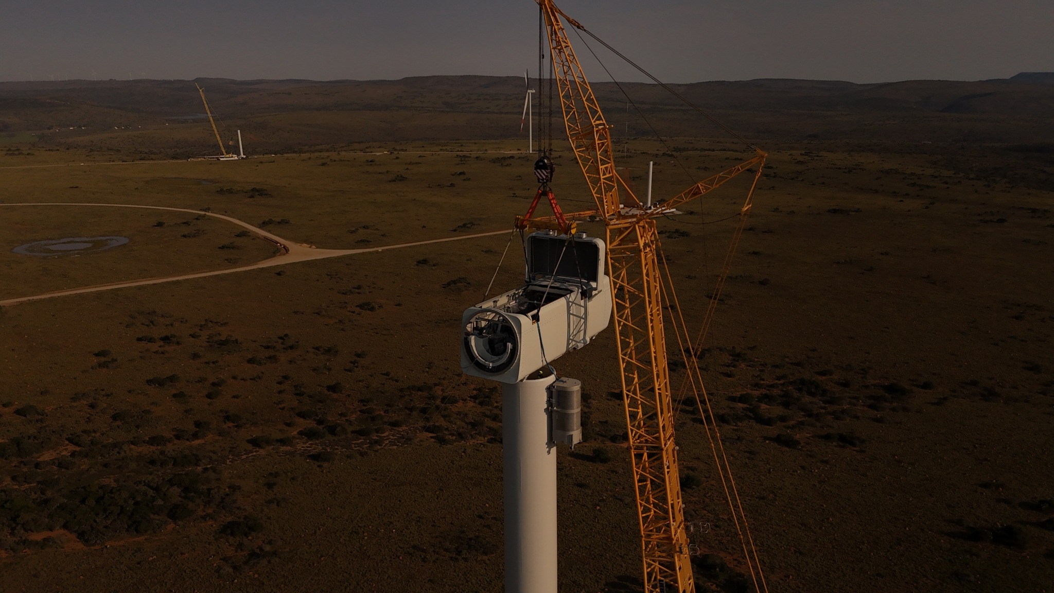 Wind turbine nacelle being lifted during a construction milestone